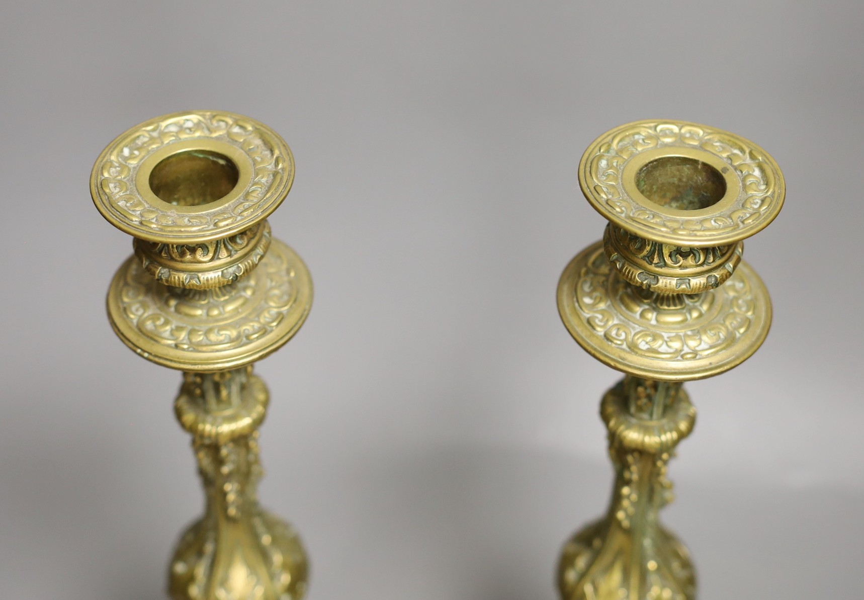 A pair of 19th century ornate brass candlesticks, 31cms high